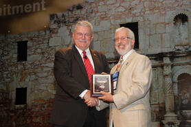 Ron Jarnagin (left), president of ASHRAE, congratulates Jim Newman on receiving the Distinguished Service Award at the ASHRAE Annual Conference. 